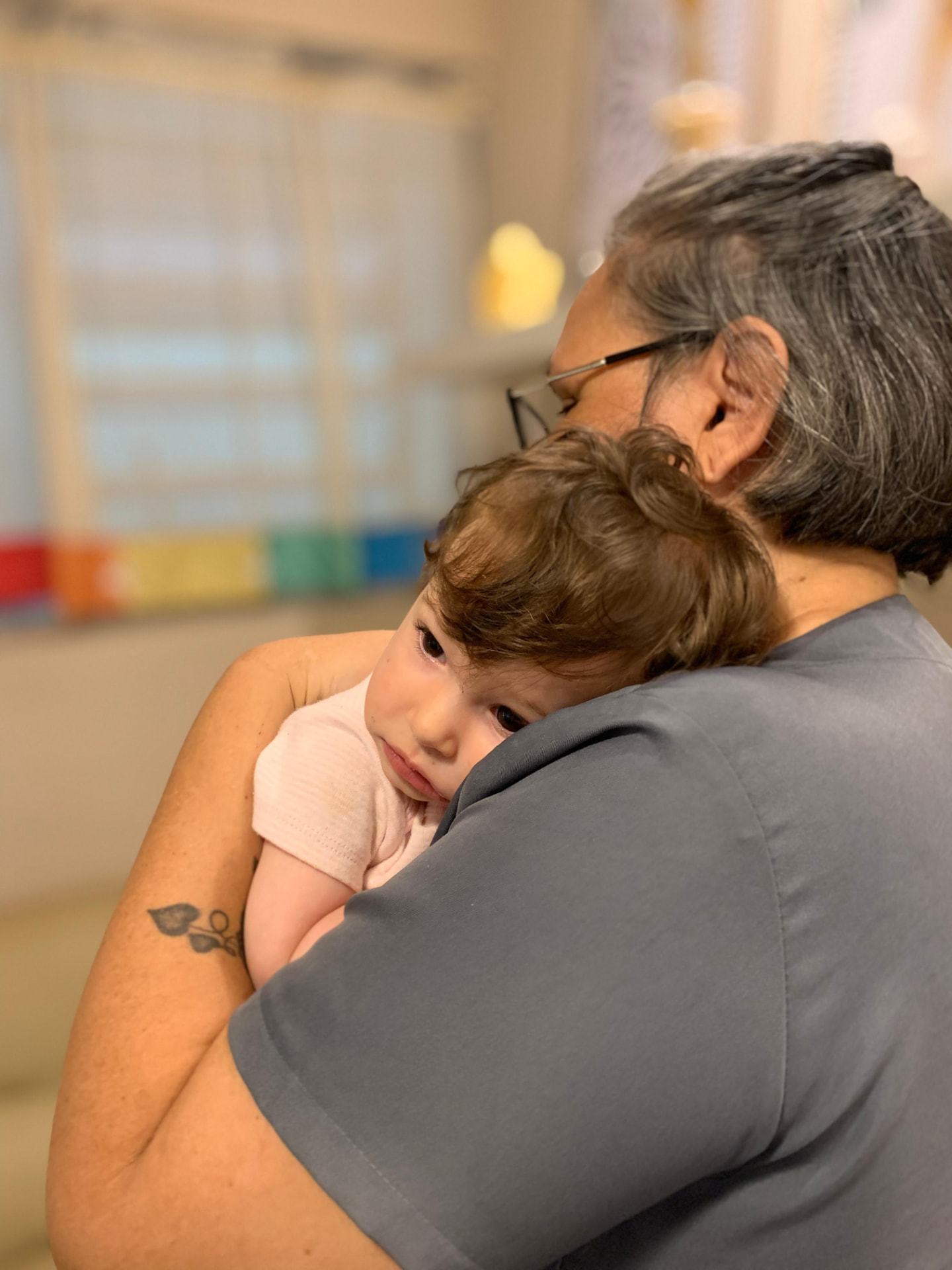 Bebê acolhido no colo por uma educadora da Escola Anteninha