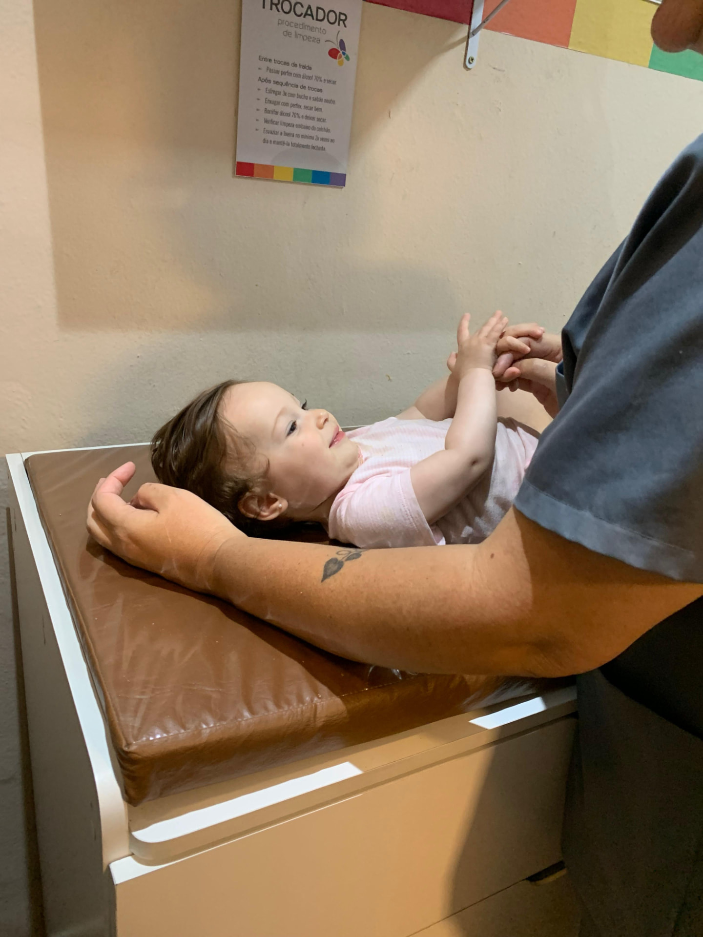 Bebê interagindo com uma educadora durante um momento de cuidado